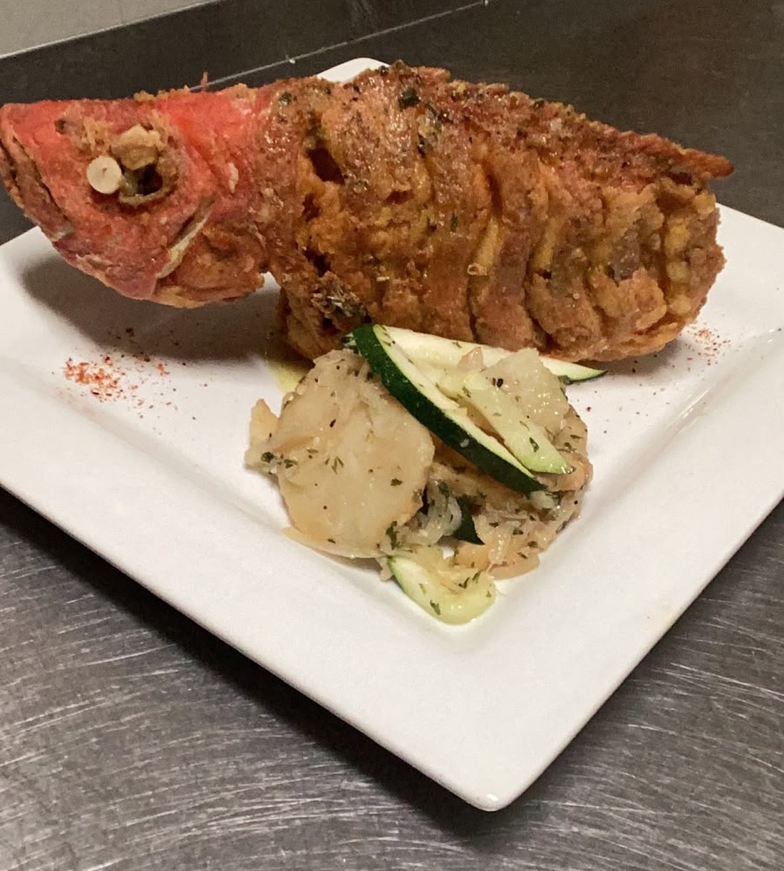 Whole fried cubera snapper with herb potatoes and zucchini