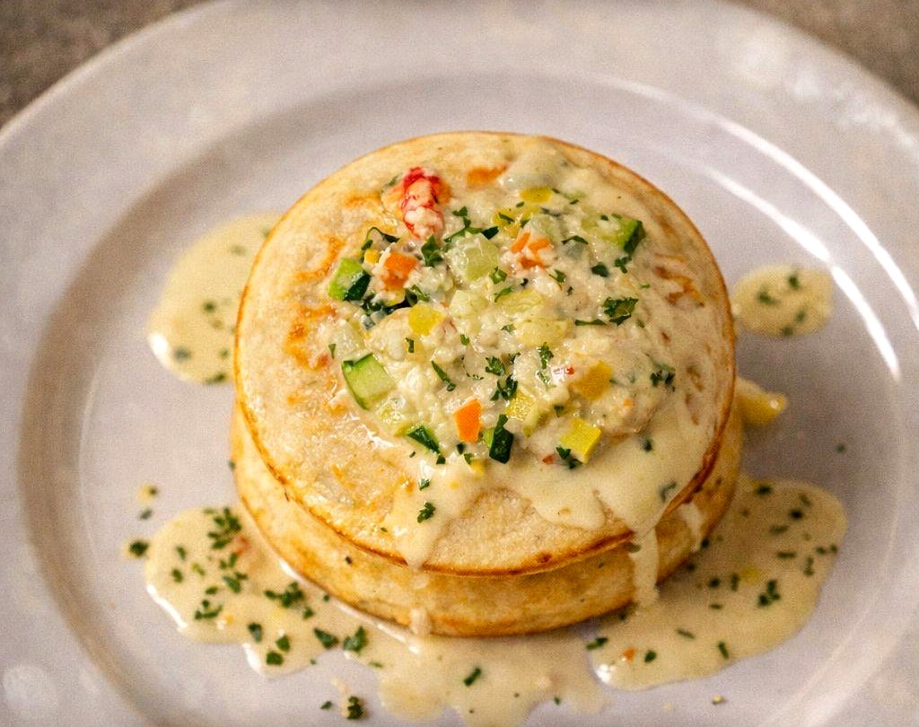 Lobster pancake layered with garden vegetables and a buttery cream sauce