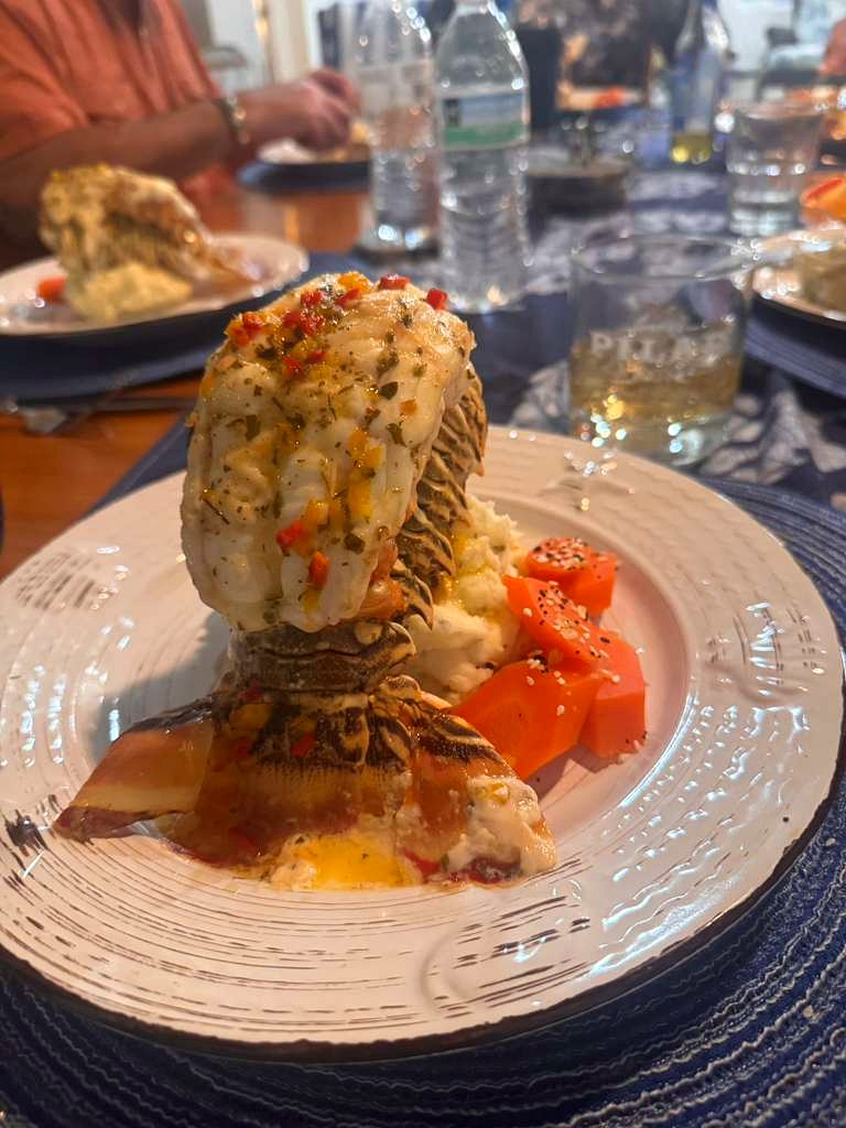 Grilled lobster tail served at a private dinner table during a villa stay